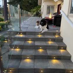 Locking in DekTek's luxury concrete deck tiles on stairs with aluminum edge trim in Pebble Beach California